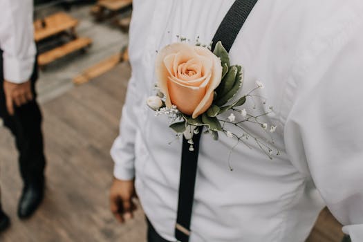 Close-up of a peach rose boutonniere on a groom